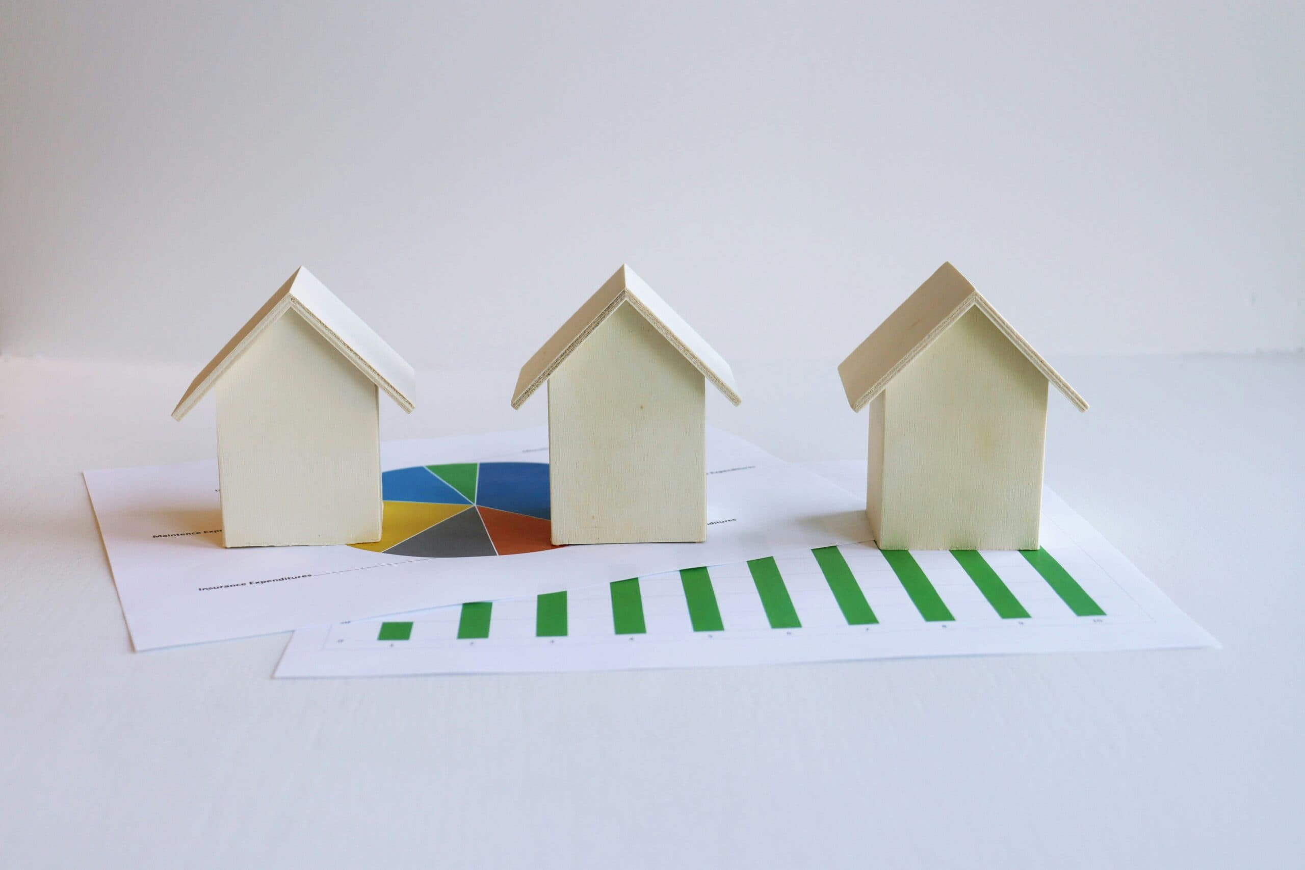 Wooden toy homes on pie chart and graph